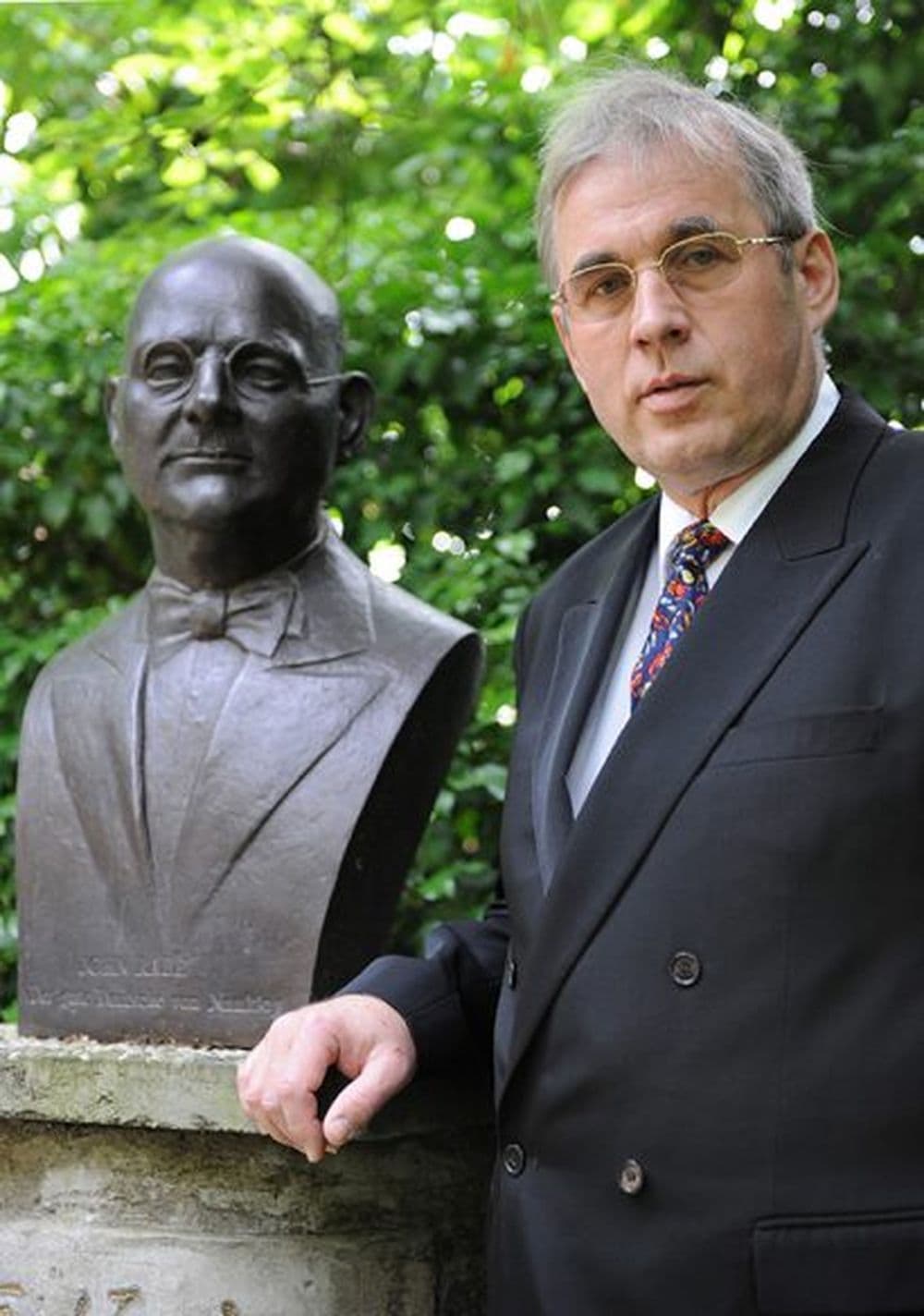 Thomas Rabe steht neben der Statue seines Großvaters (Von Thomas Rabe und dem John Rabe Kommunikations Zentrum e.V. in Heidelberg freundlicherweise zur Verfügung gestellt